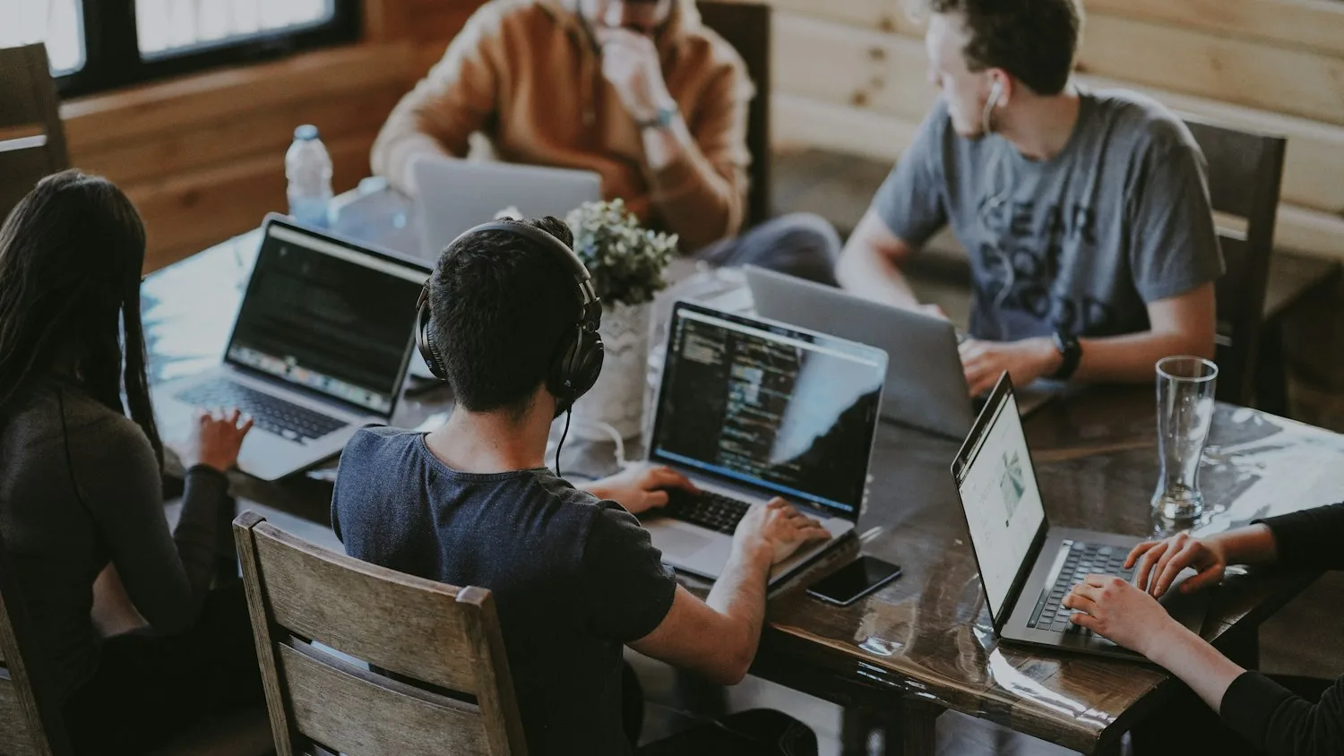 An agency team collaborating around a table of laptops